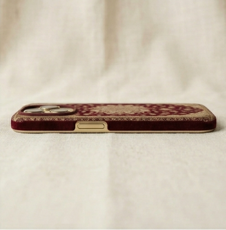Phone case with intricate design on a beige fabric background