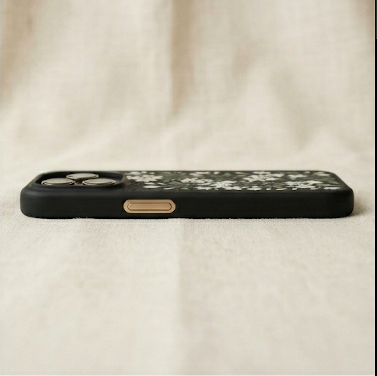 Black phone case with floral design on a beige fabric background